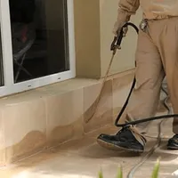 General pest control technician spraying exterior perimeter around a home in Columbia, SC