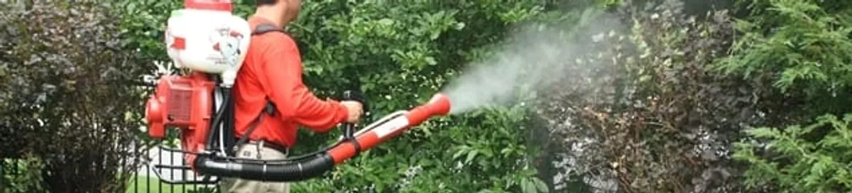 Mosquito control technician fogging shrubs and landscaping for mosquito treatment in Columbia, SC